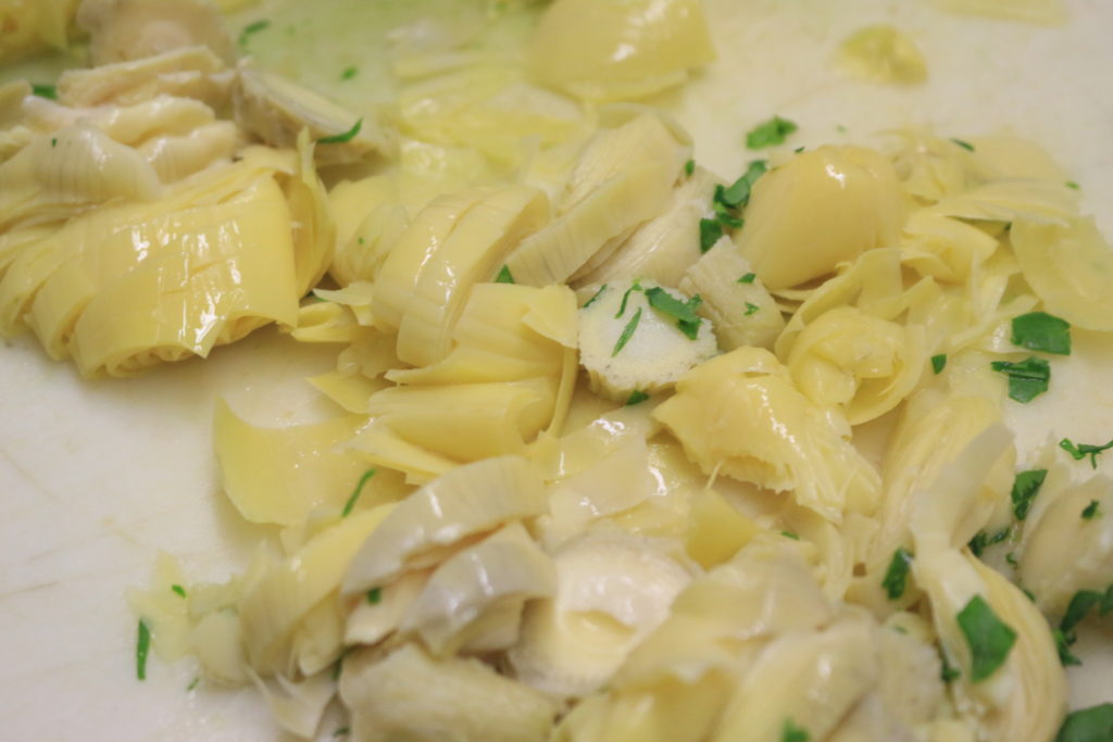 artichokes being cooked for spinach and artichoke dip