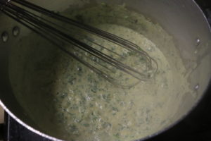 whisking together ingredients for spinach and artichoke dip