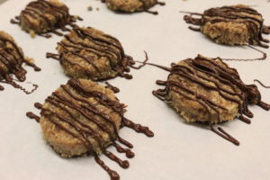A tray of finished paleo samoa cookies topped with chocolate drizzle.