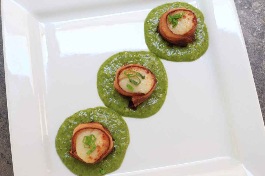 Delicious bacon wrapped scallops are served in a paleo kale pesto sauce.