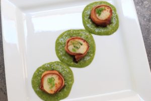 Delicious bacon wrapped scallops are served in a paleo kale pesto sauce.